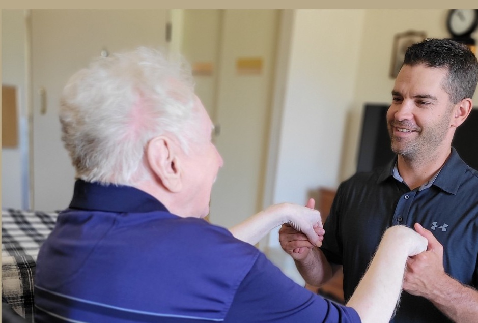 Physical therapist providing one-on-one care to an older adult at home